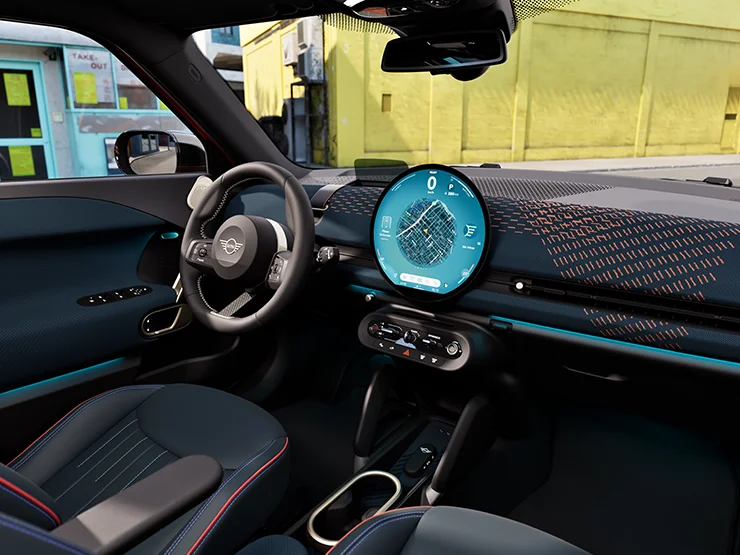 Interior view of the all-electric MINI Aceman with focus on the dashboard, the interaction unit and the steering wheel.