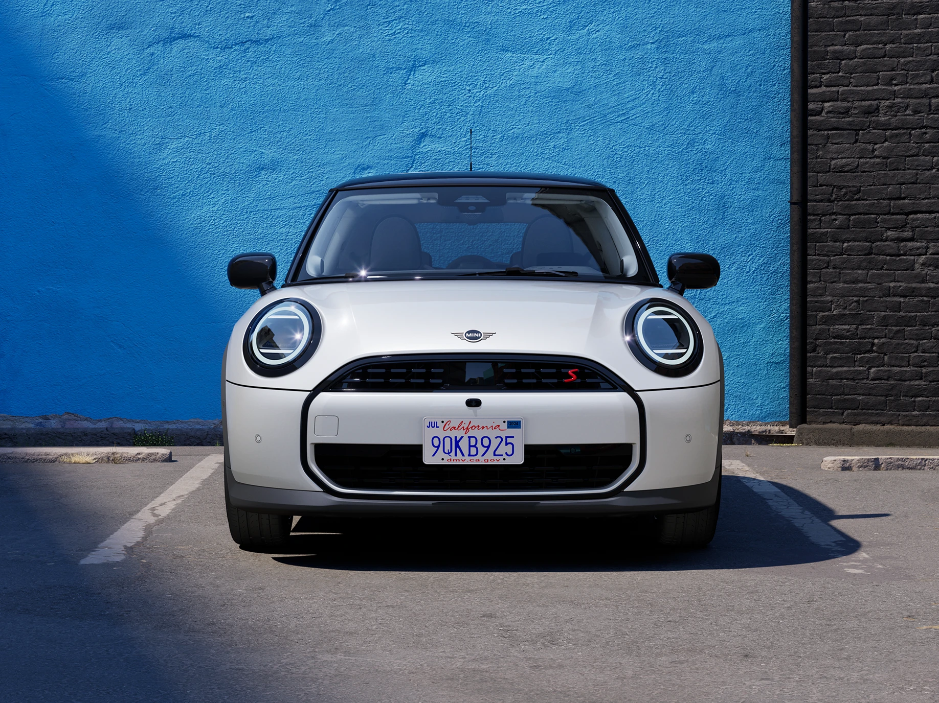 Front view of the MINI Cooper in Nanuq White with Black Roof parking.