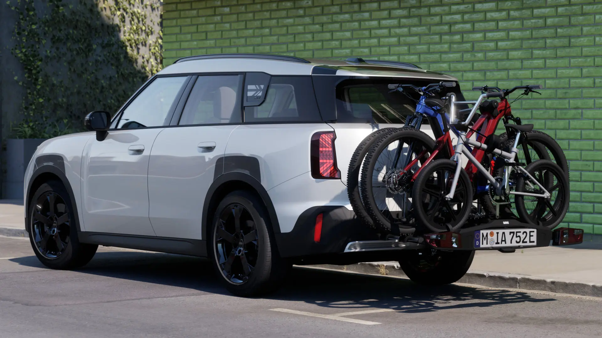 MINI Aceman in Nanuq White equipped with MINI rear bike rack Pro 3.0, carrying two mountain bikes and a child’s bike.