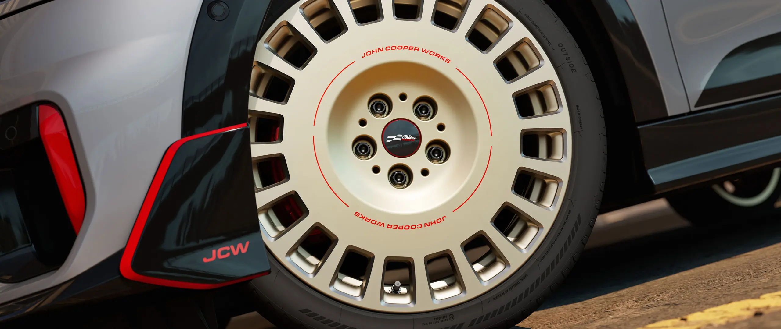 Close-up of the details on a 18" JCW Rallye Spoke 964 wheel in Bicolour Vibrant Silver and diamond-milled and front winglet.