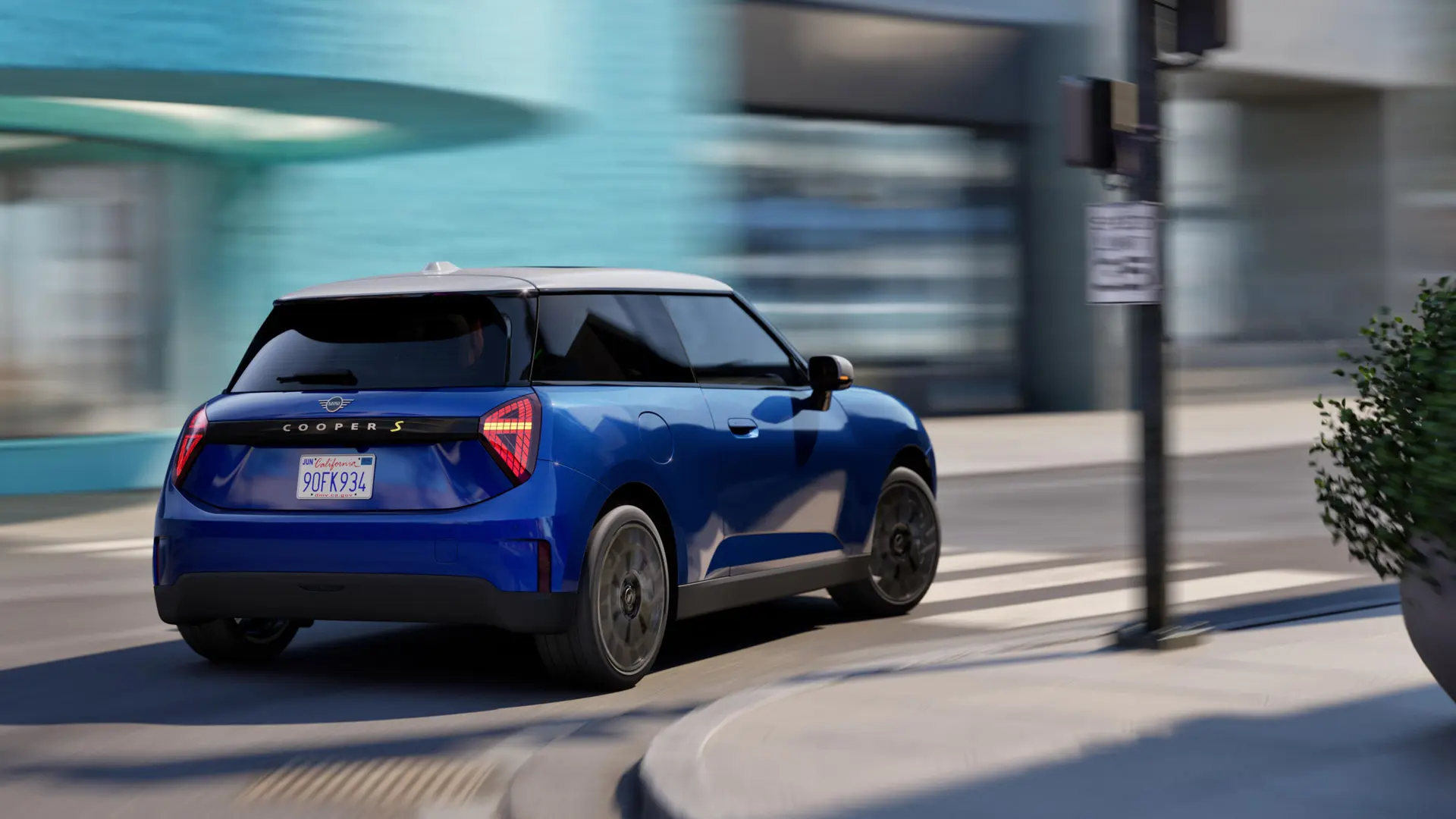 A MINI Cooper drives dynamically around the curve.